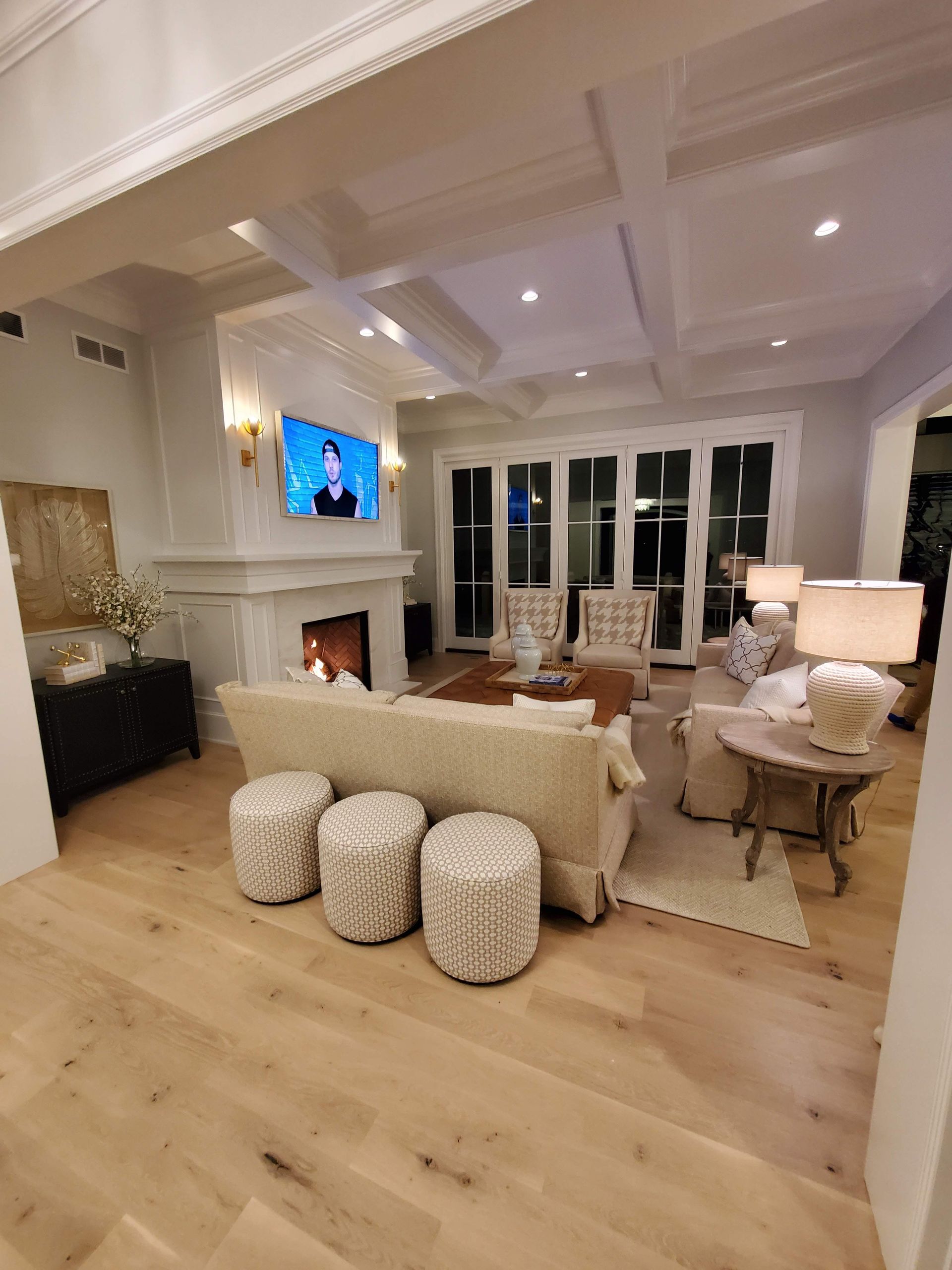 A living room with a couch , chairs , ottomans and a fireplace.