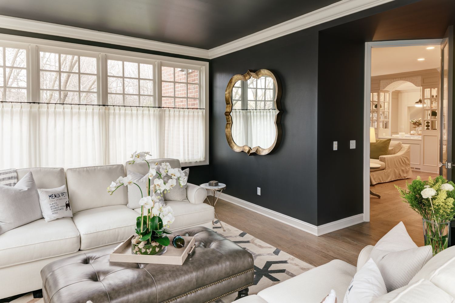 A living room with a couch , coffee table , and mirror.