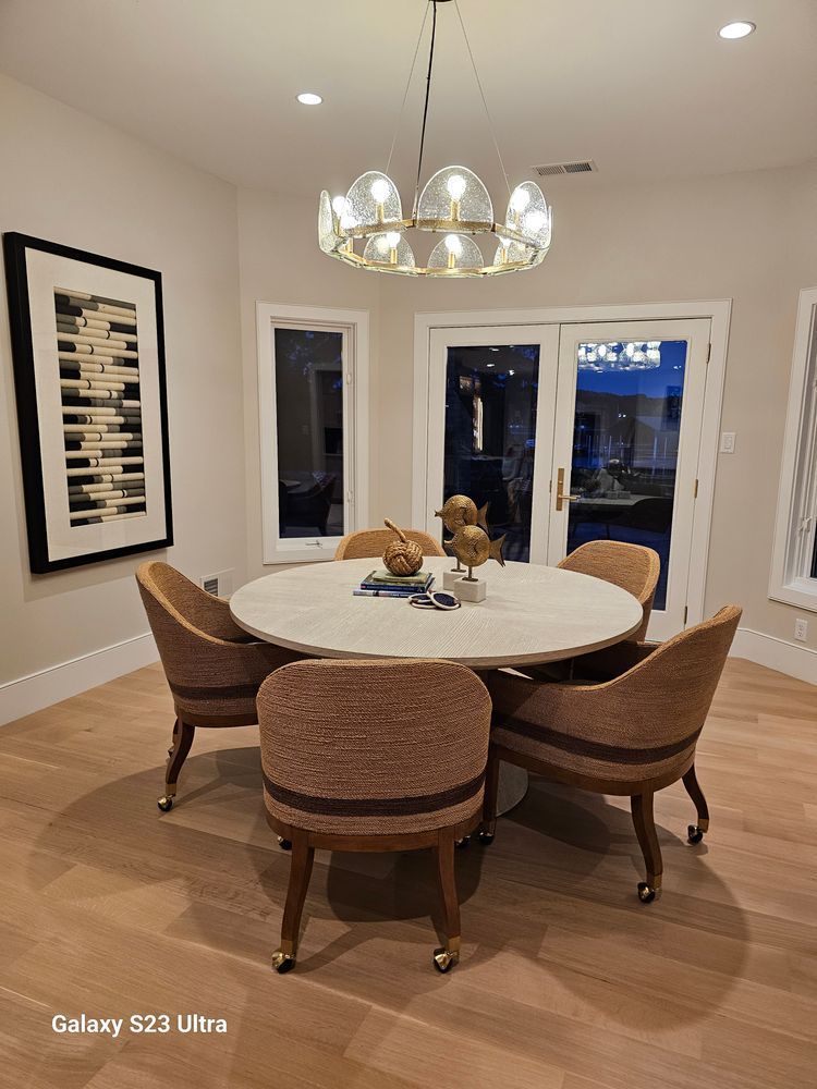 A dining room with a round table and chairs and a chandelier.