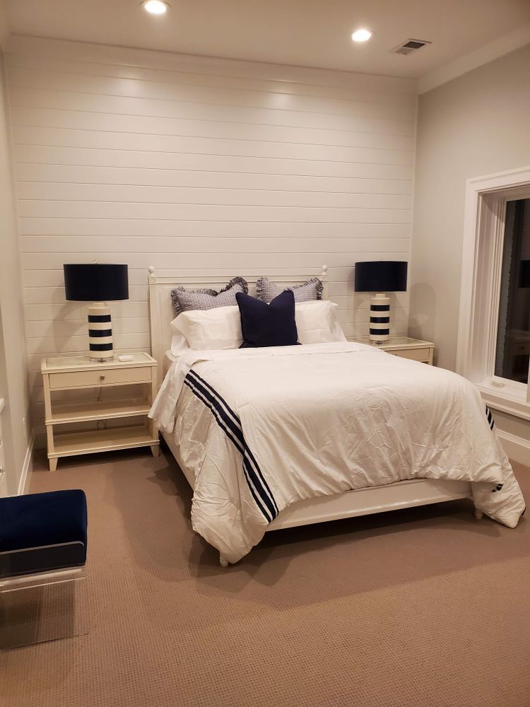 A bedroom with a bed , nightstands , lamps and a window.