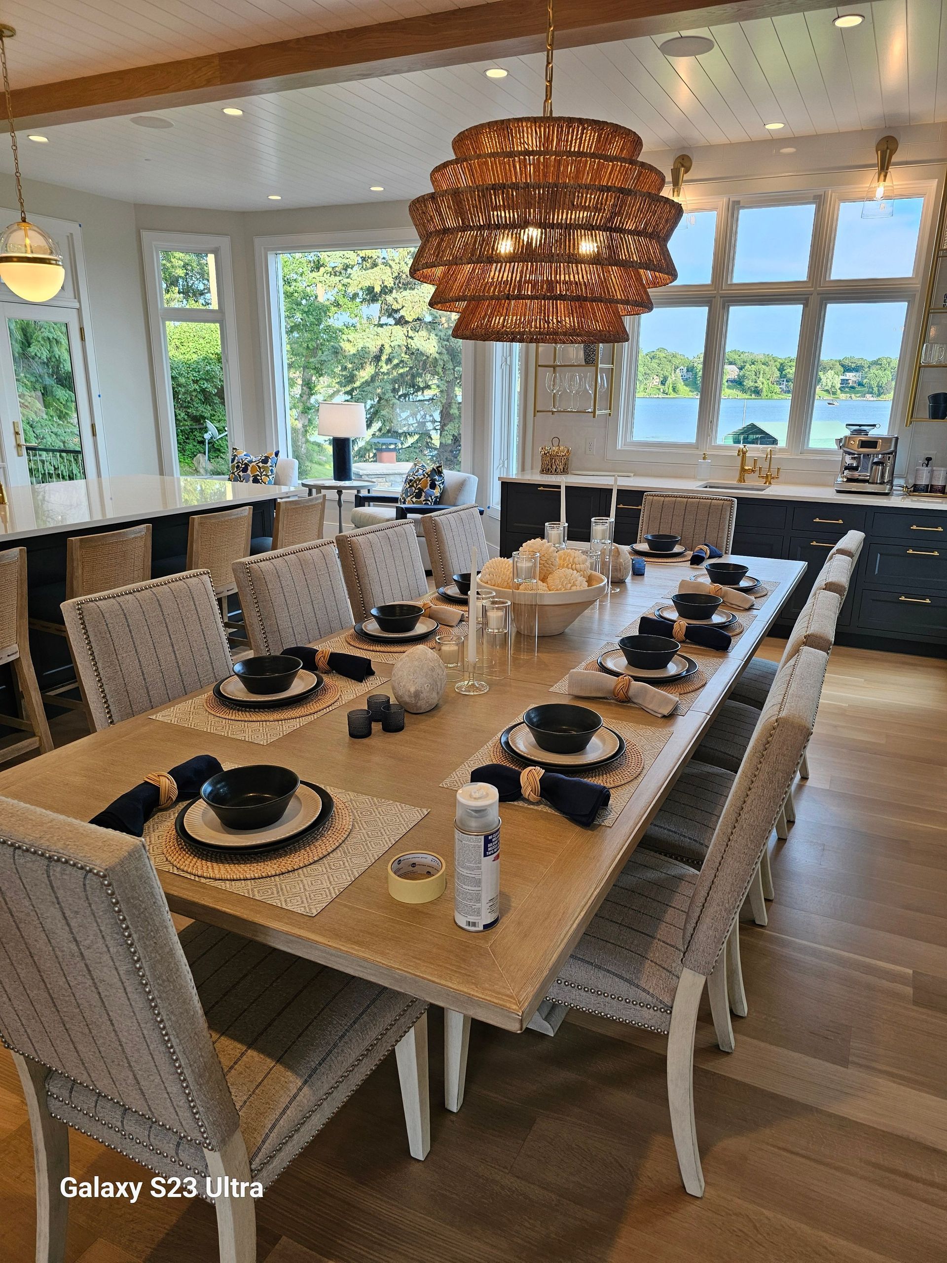 A large dining room table with a lot of chairs and plates on it.