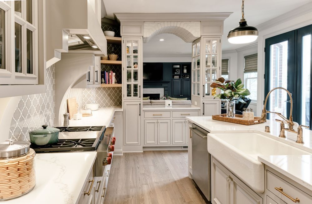 A kitchen with white cabinets , stainless steel appliances , a sink and a stove.