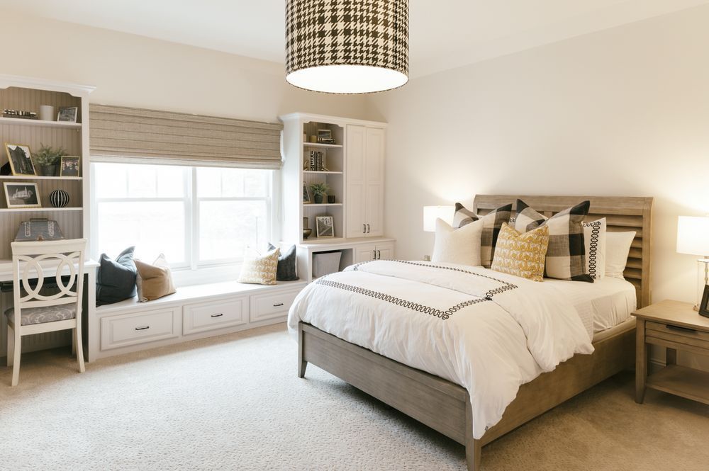 A bedroom with a bed , desk and window seat.