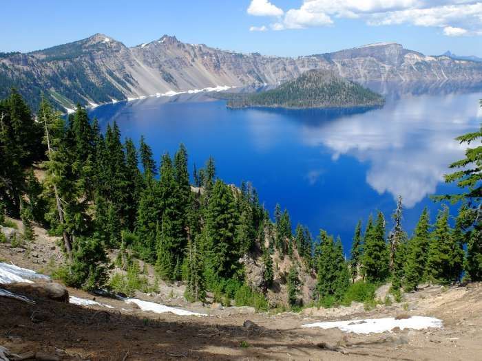 A large blue lake surrounded by trees and mountains