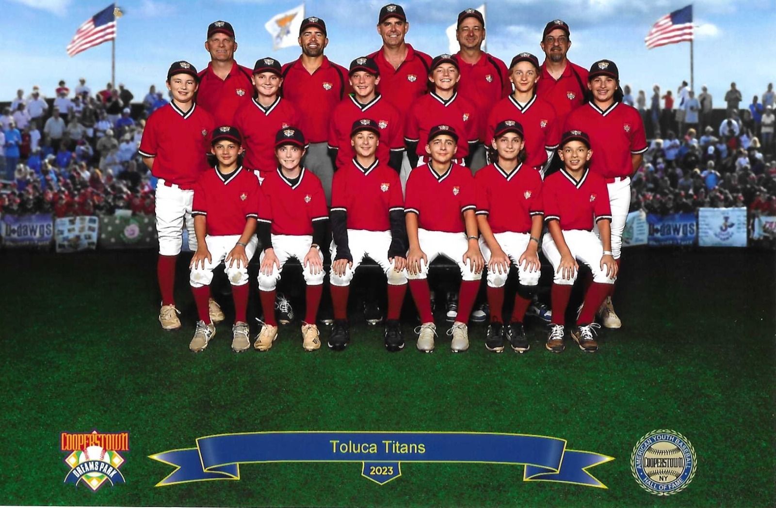 Baseball team photo, red jerseys, white pants, standing on a green field in front of a stadium crowd.