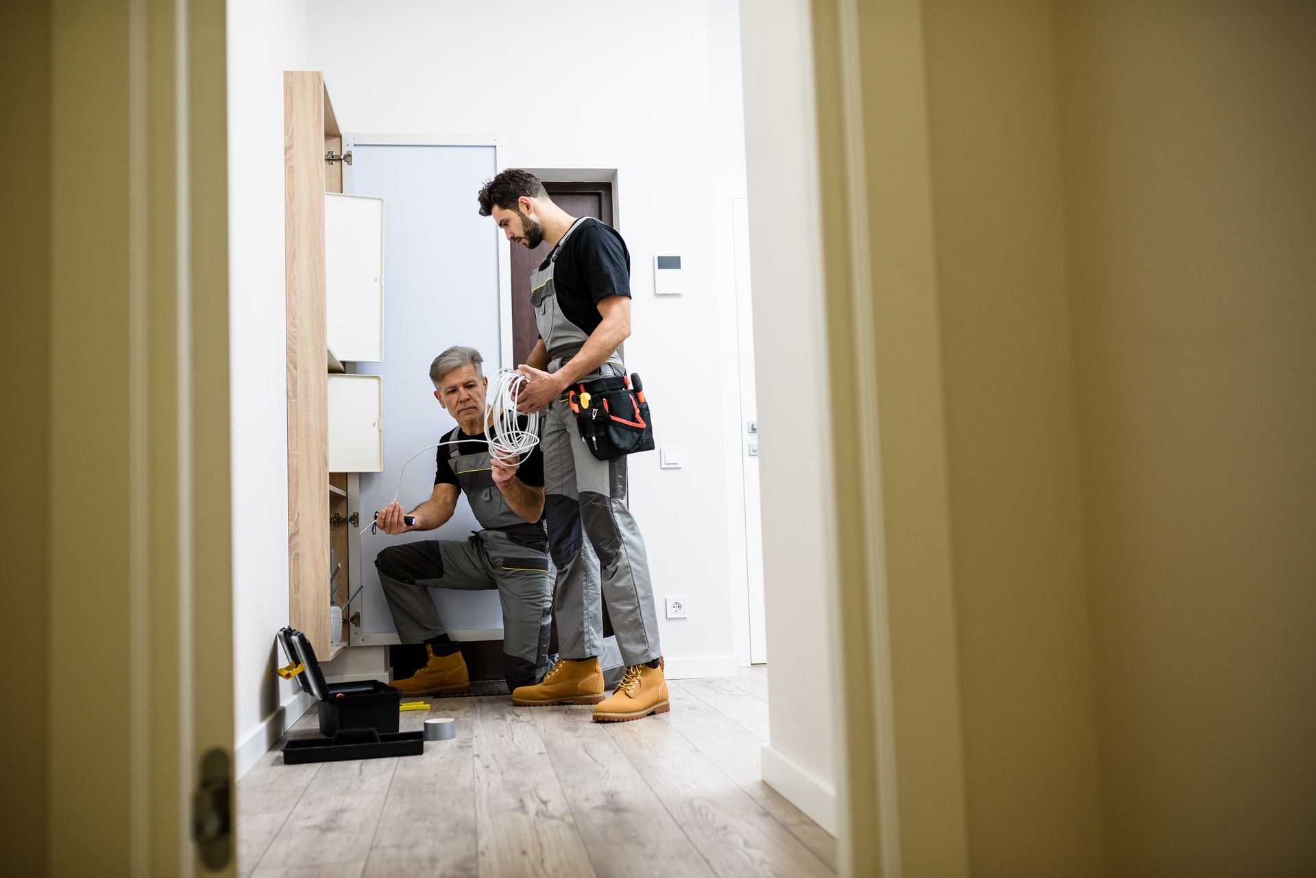 Repairman in uniform working, installing ethernet cable.