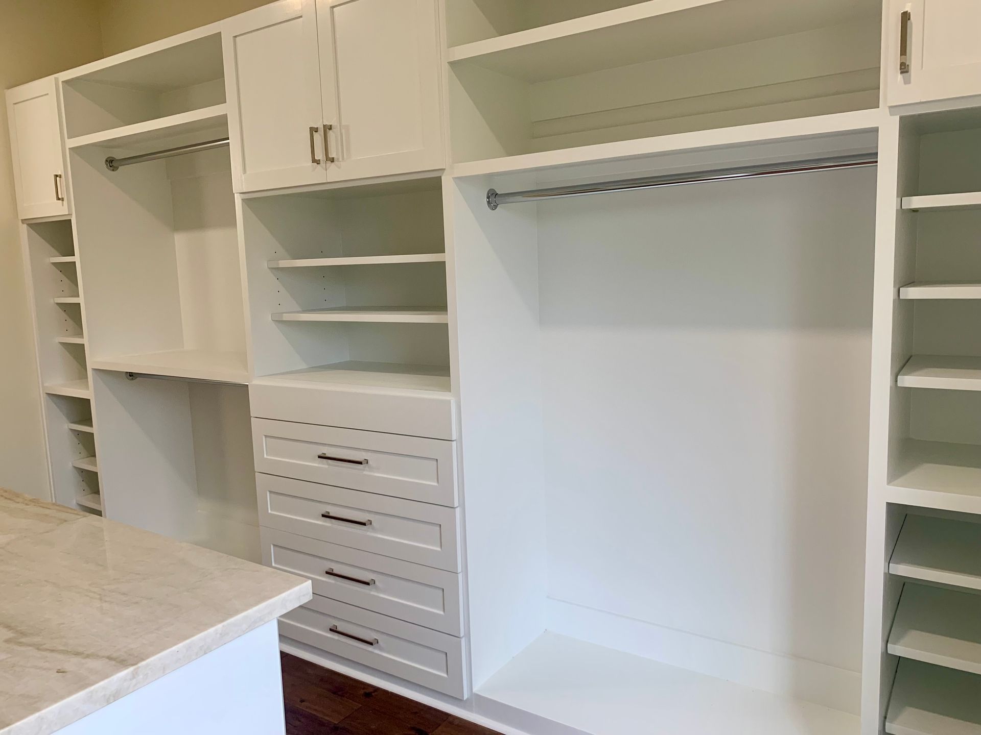 White custom closet with drawers, shelves, and hanging rods.