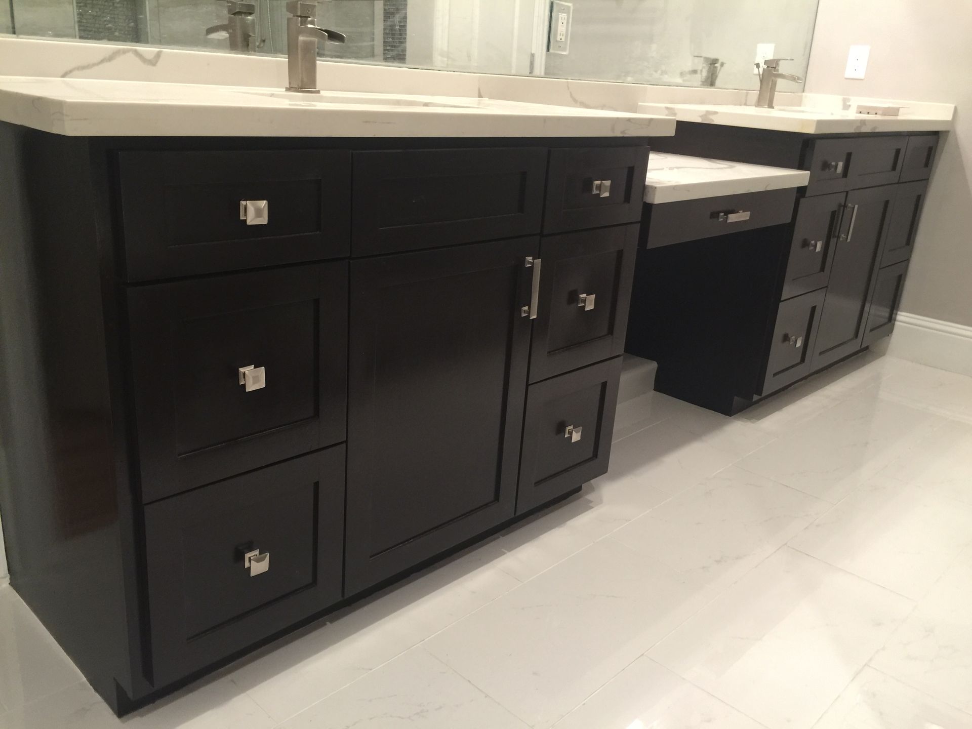 Dark brown bathroom vanity with white countertop, chrome hardware, and white tile floor.