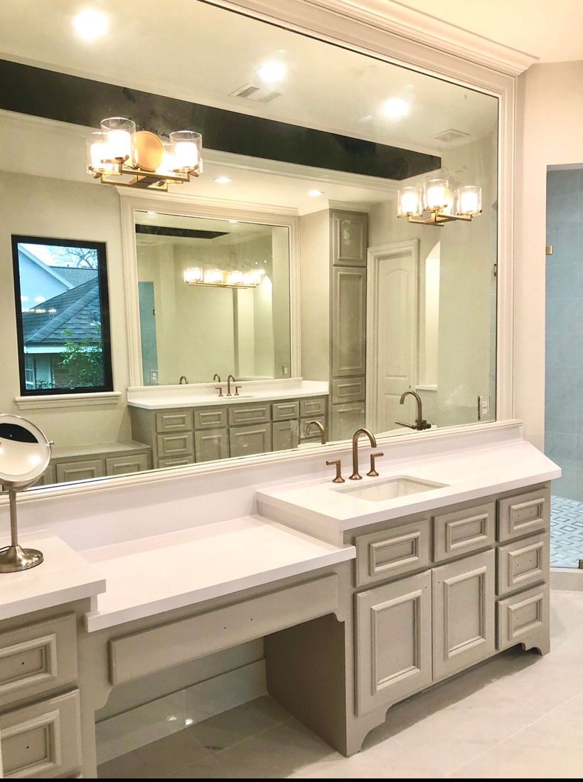 Bathroom with large mirror, vanity, and double sinks. 