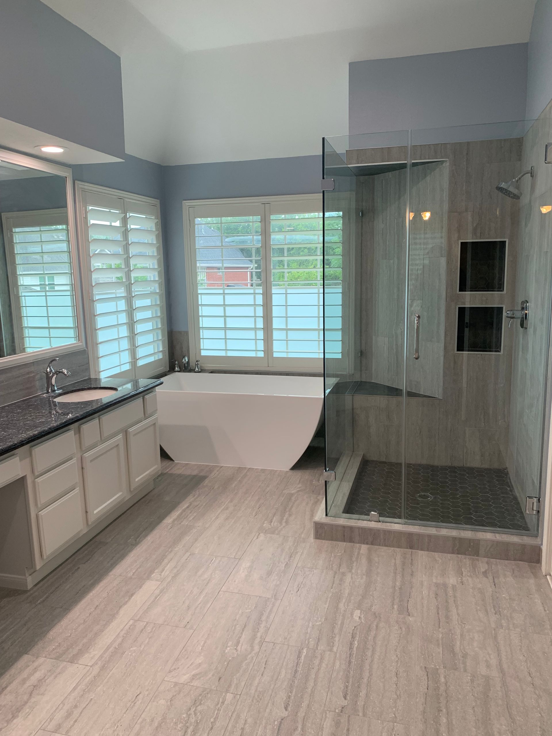 Spacious bathroom with glass shower.
