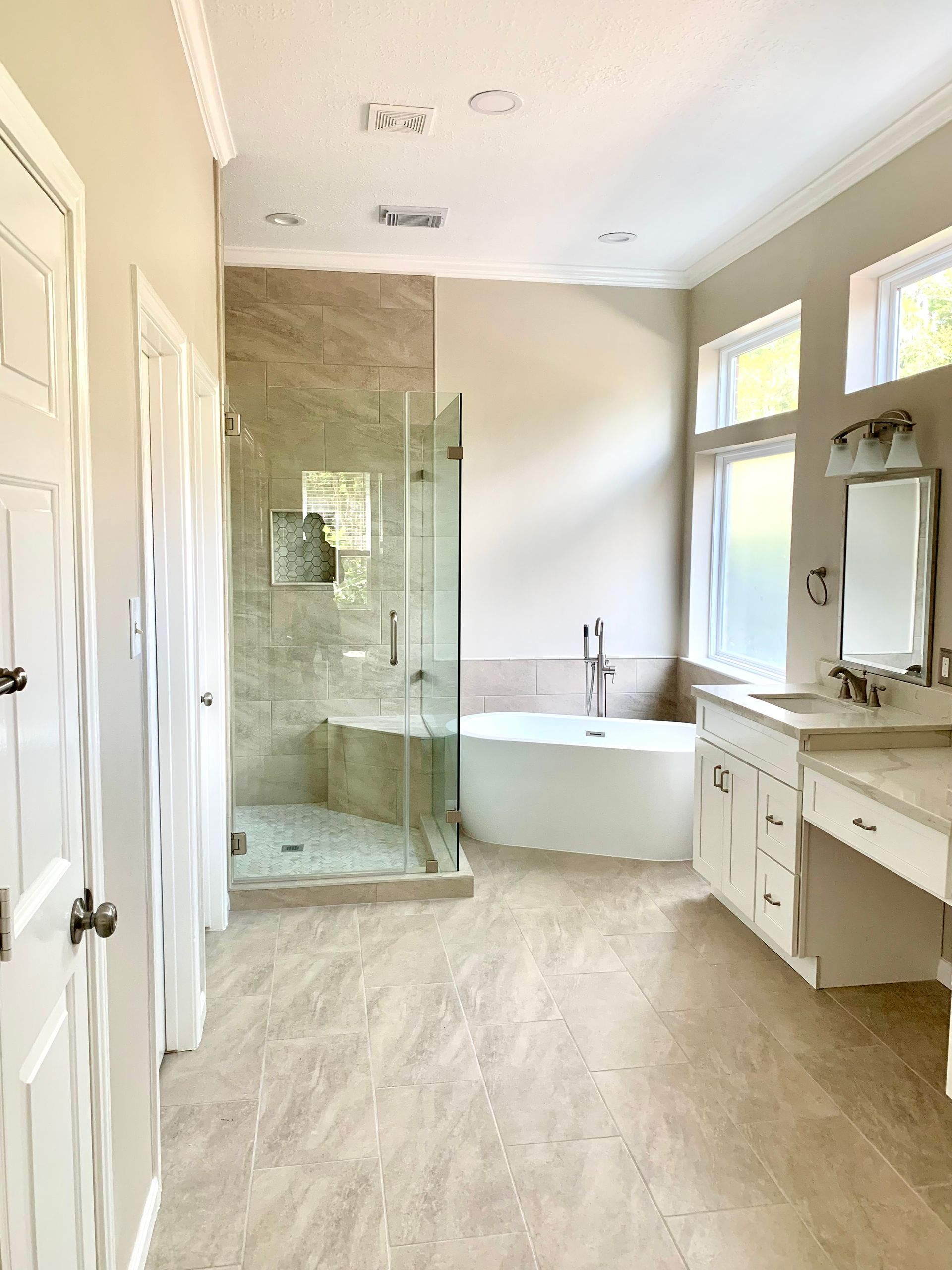 Spacious bathroom with glass shower.