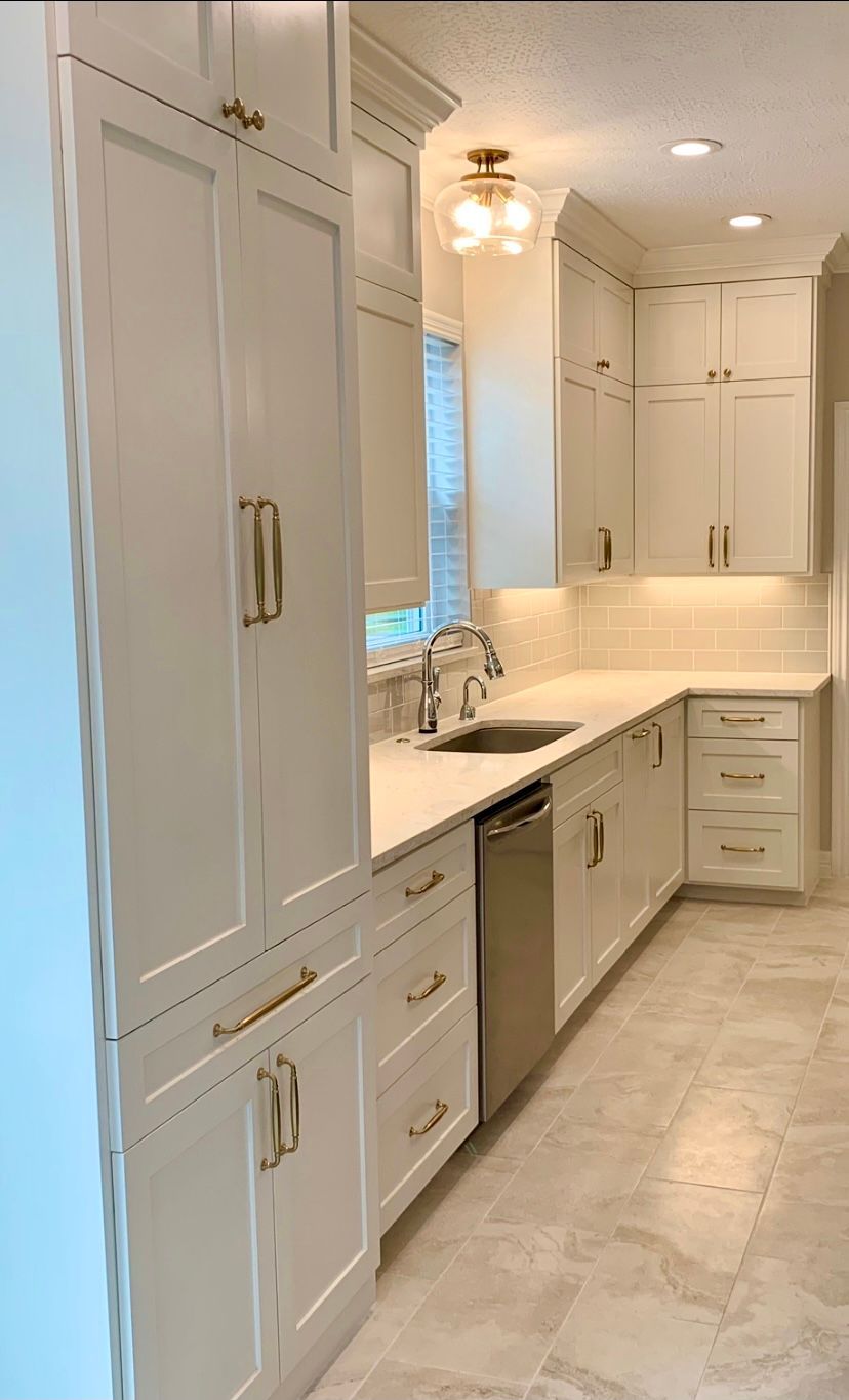 White kitchen with cabinets, drawers, appliances, countertops, and a sink.