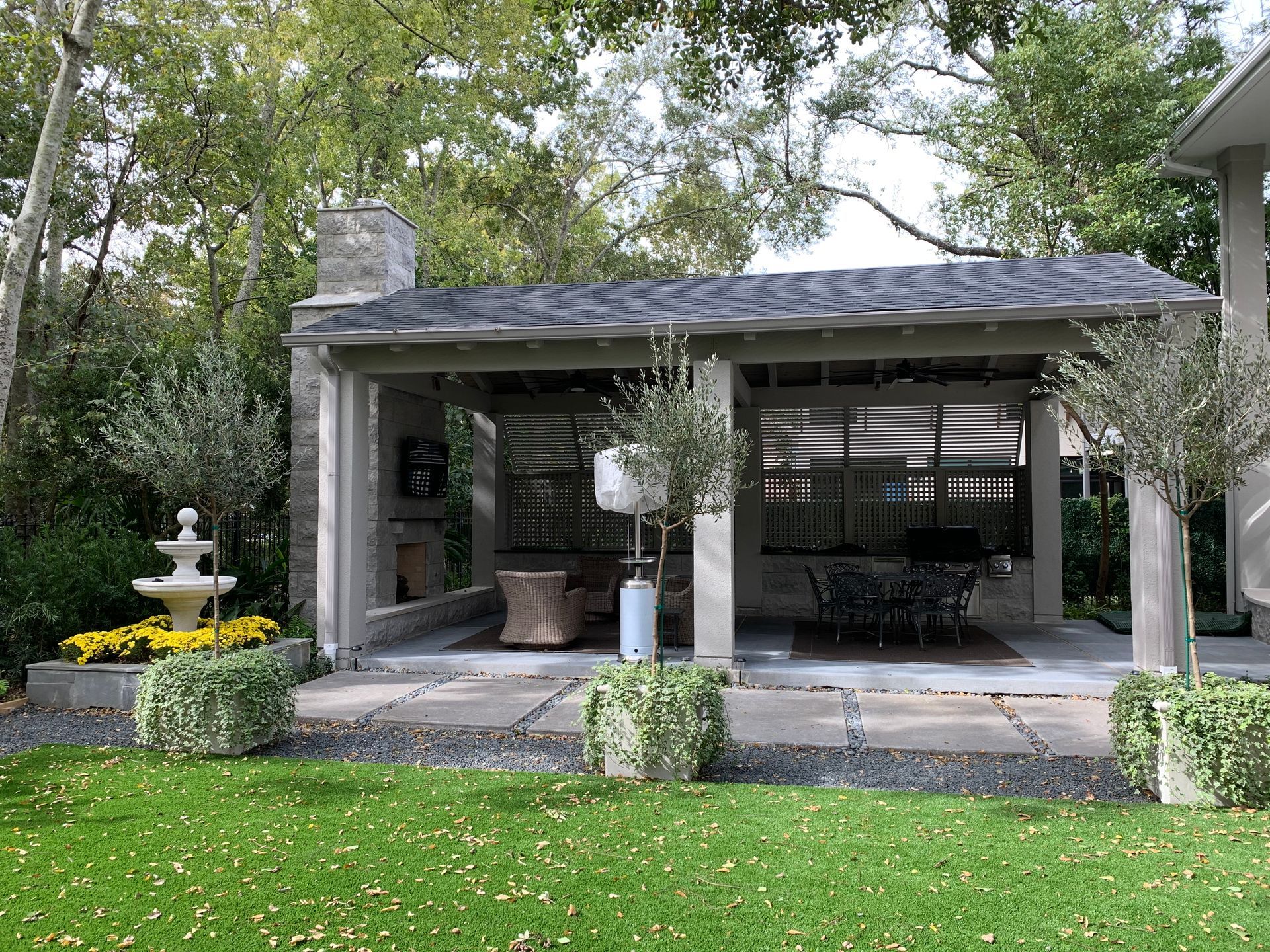 Outdoor patio with stone floor, covered by a roof. 