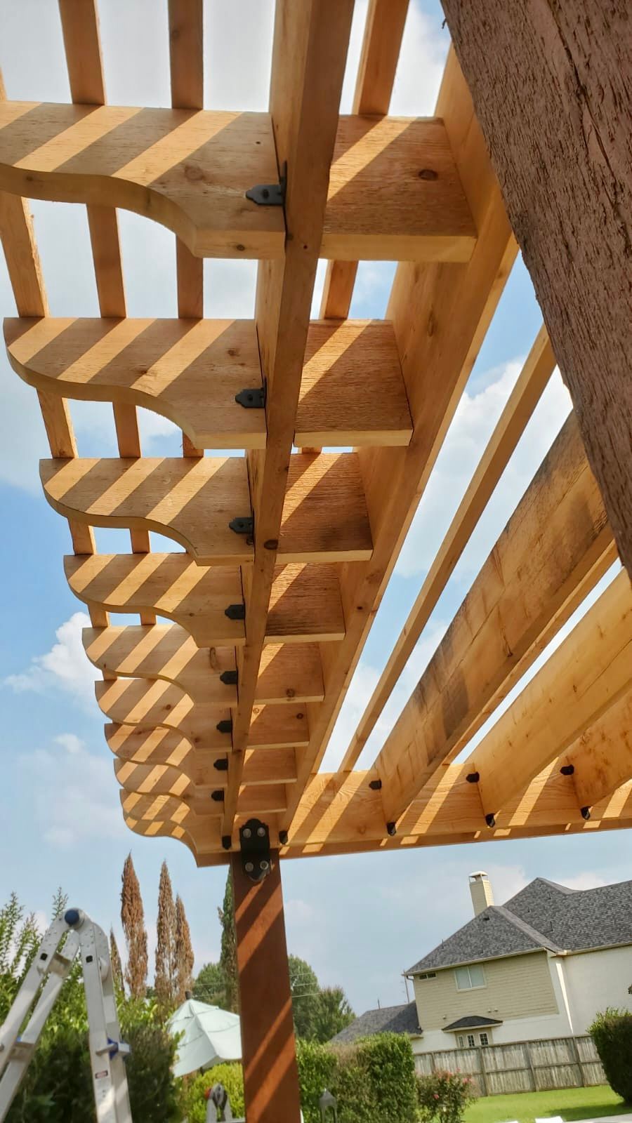 Wooden pergola frame with a blue sky background. 