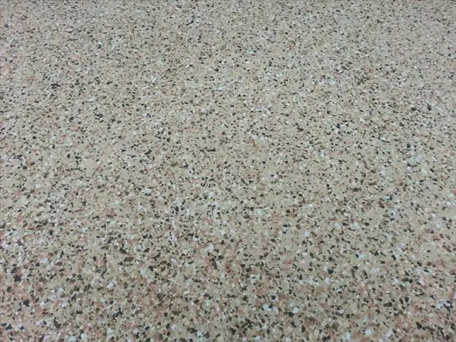Close-up of a speckled, light-brown surface, likely terrazzo or a similar material.