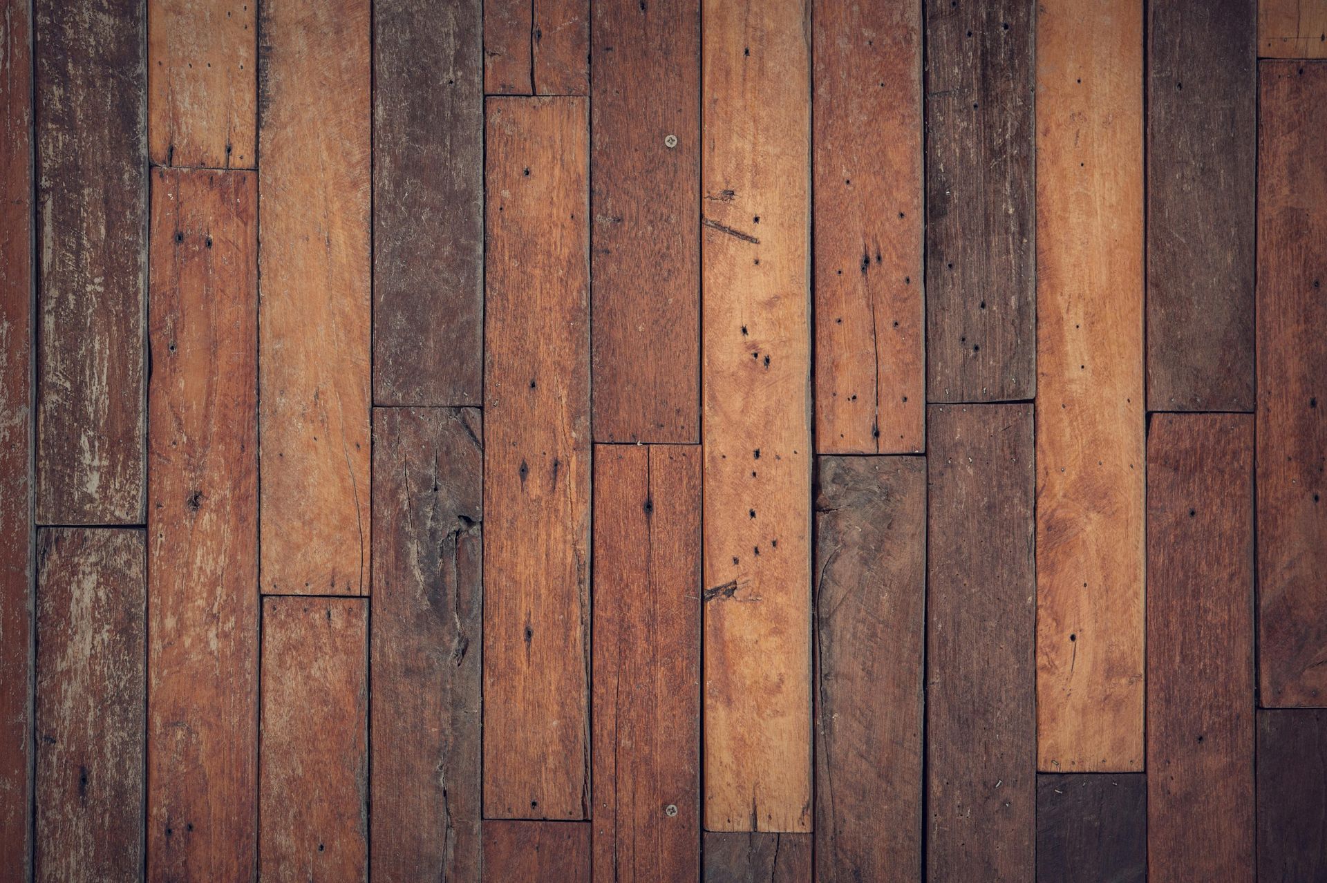 A close up of a wooden floor with a row of wooden planks.