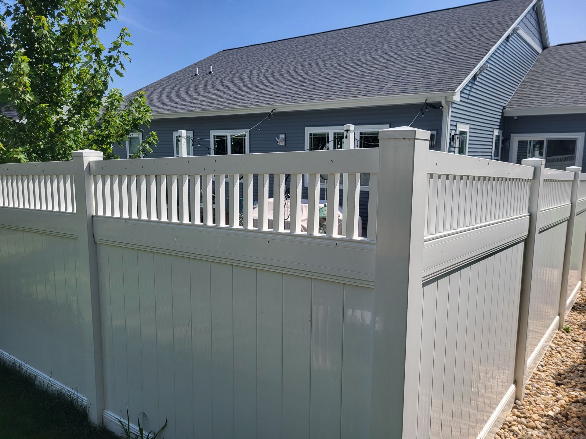 A close up of a black fence with trees in the background.