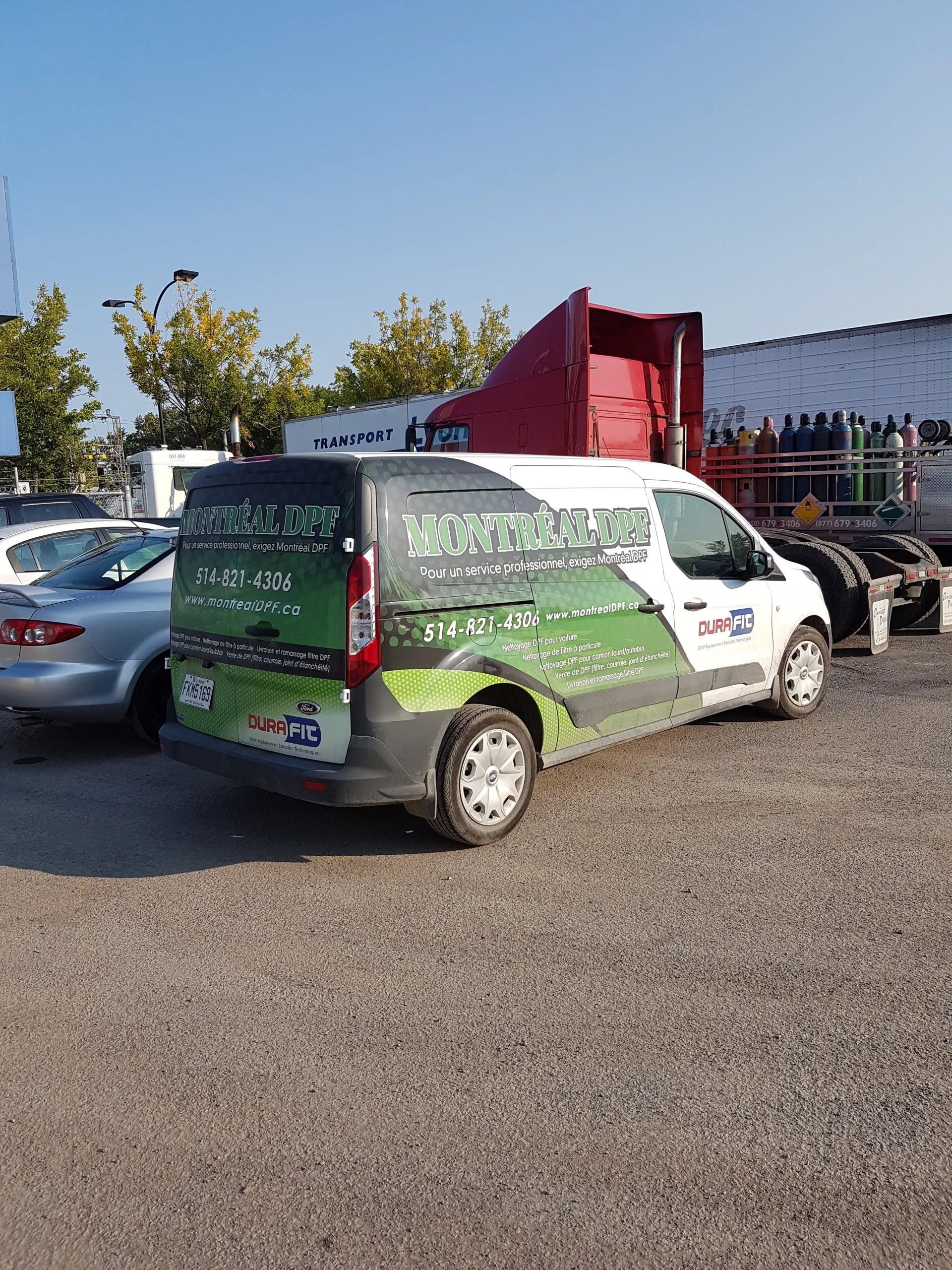 Une camionnette est garée sur un parking à côté d'un camion.