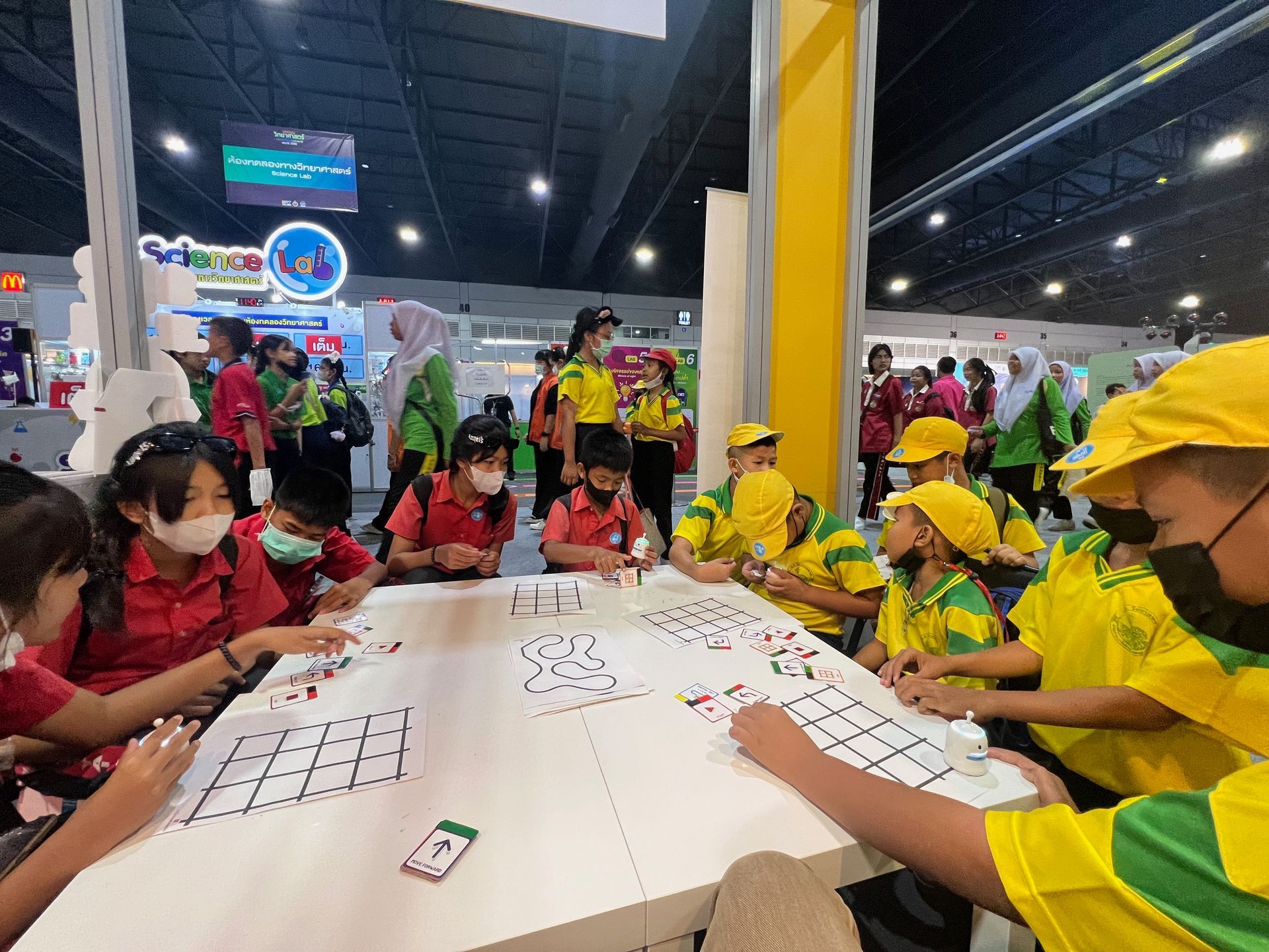 A group of children are sitting around a table playing a game.