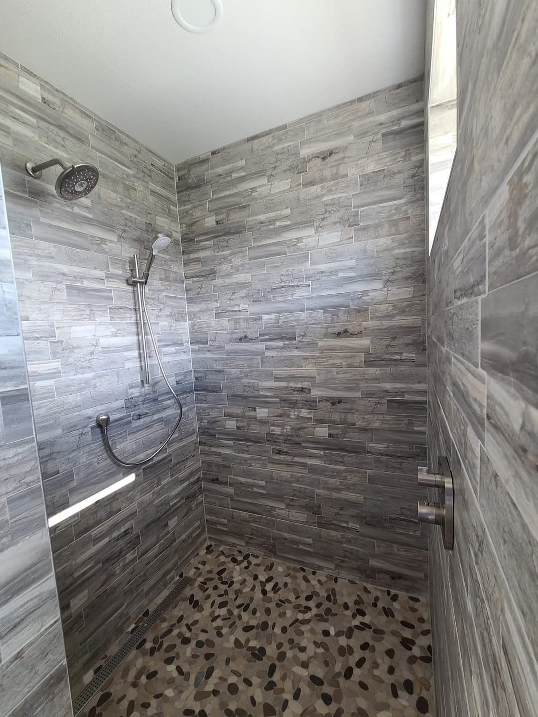 A plumber is fixing a faucet in a kitchen sink.