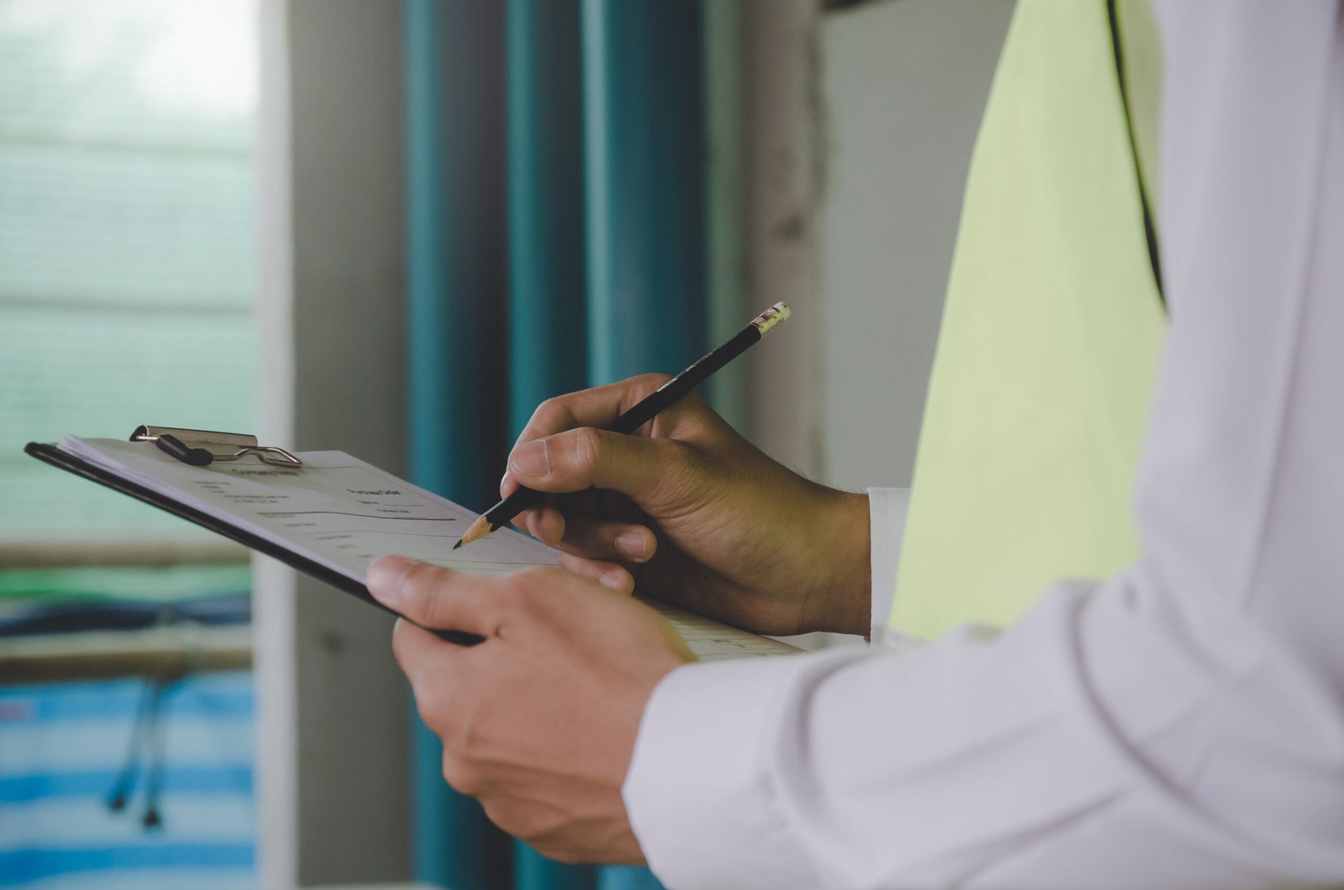 A Man is Writing on a Clipboard With a Pencil — Advanced Industry Training In South Townsville, QLD