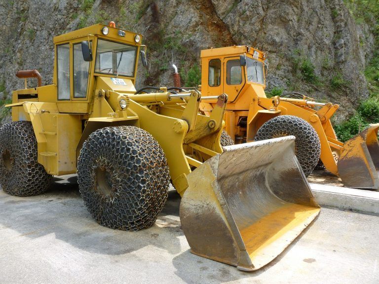 Two Yellow Bulldozers Are Parked Next to Each Other — Advanced Industry Training In South Townsville, QLD