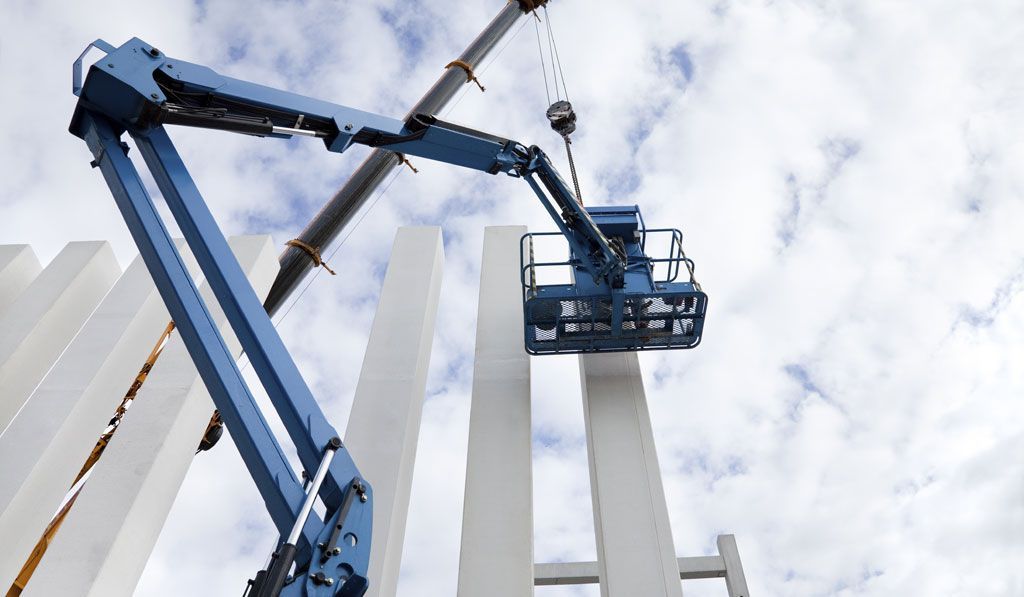 A Crane is Lifting a Concrete Pillar in a Construction Site — Advanced Industry Training In South Townsville, QLD
