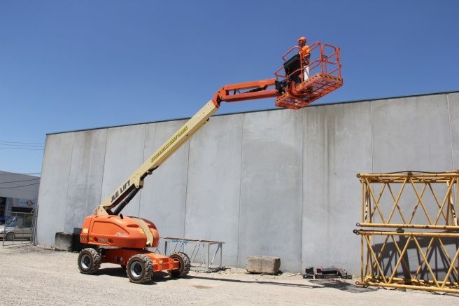 A Man is Standing on a Lift in Front of a Building — Advanced Industry Training In South Townsville, QLD