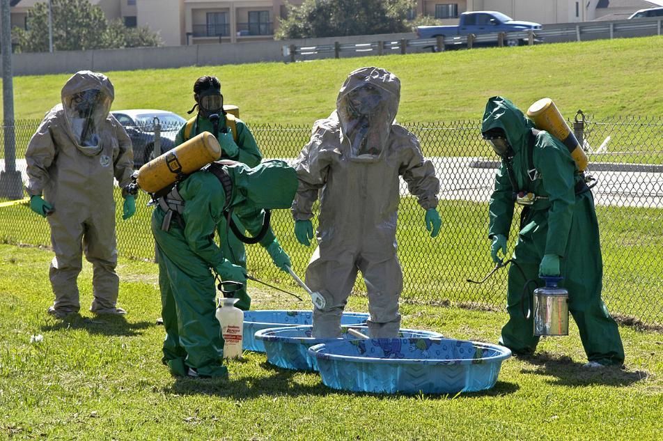 A Group of People in Protective Suits Are Standing in a Field — Advanced Industry Training In South Townsville, QLD