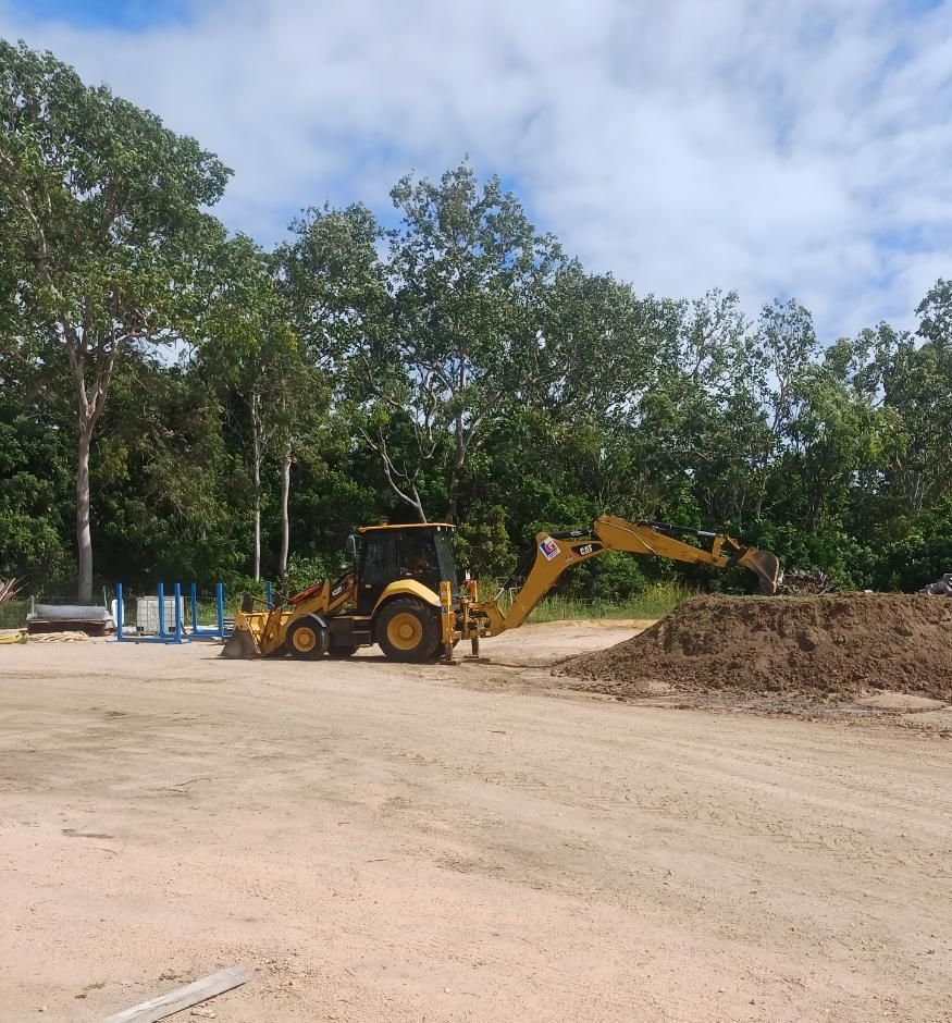 A Yellow Tractor is Moving Dirt in a Parking Lot — Advanced Industry Training In South Townsville, QLD