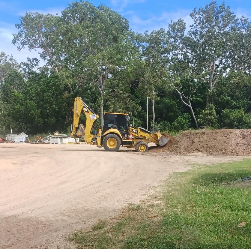 A Yellow Tractor is Driving Down a Dirt Road — Advanced Industry Training In South Townsville, QLD