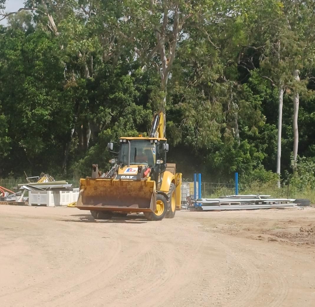 A Yellow Bulldozer is Driving Down a Dirt Road — Advanced Industry Training In South Townsville, QLD