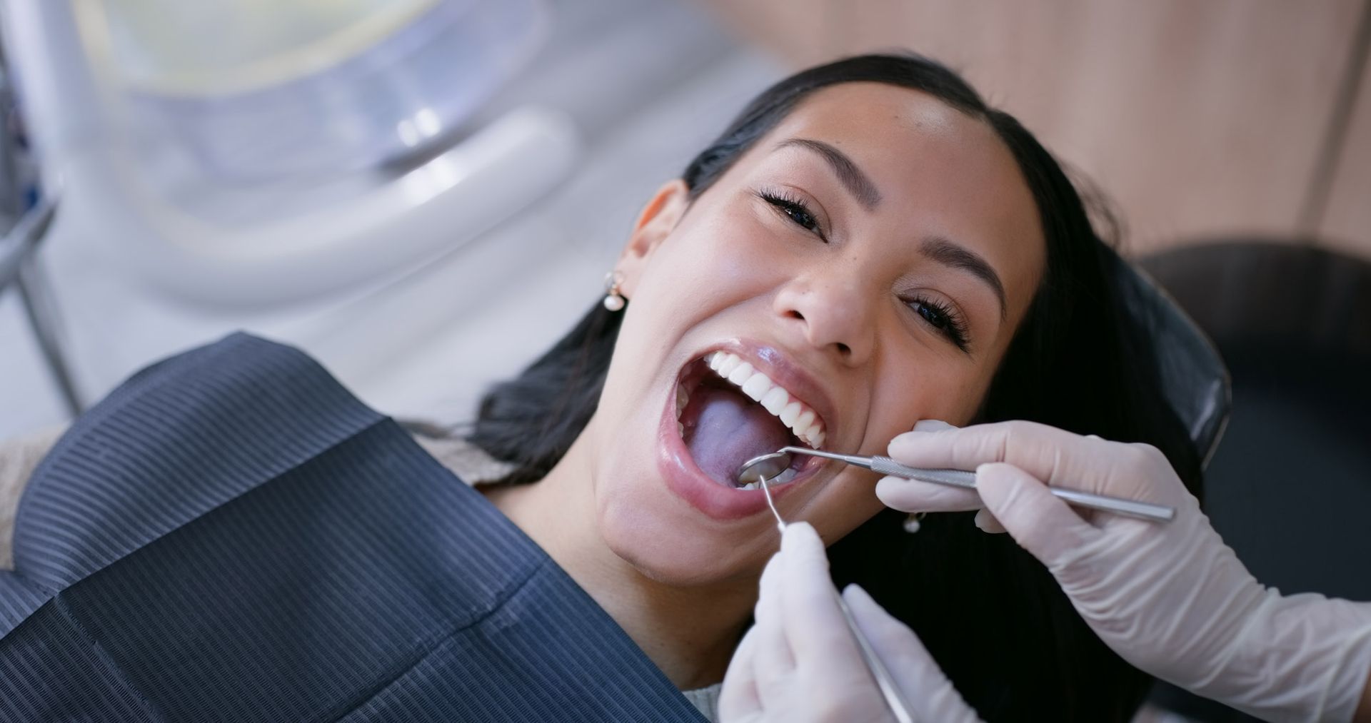 Dentist, woman and smile with mirror for teeth whitening, oral hygiene and consultation with gloves