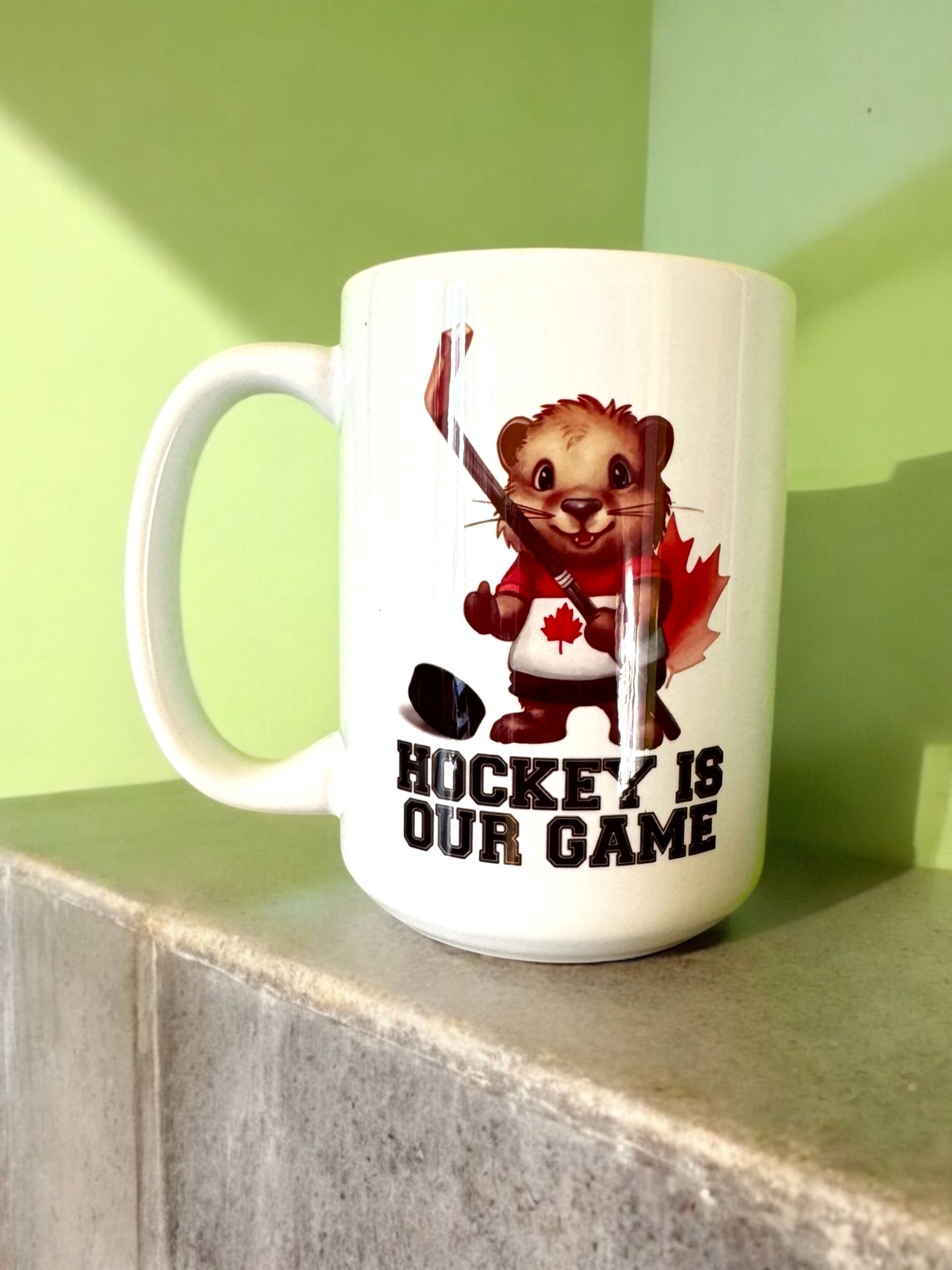 White mug with hockey-playing cartoon beaver wearing a Canadian hockey jersey; text says 