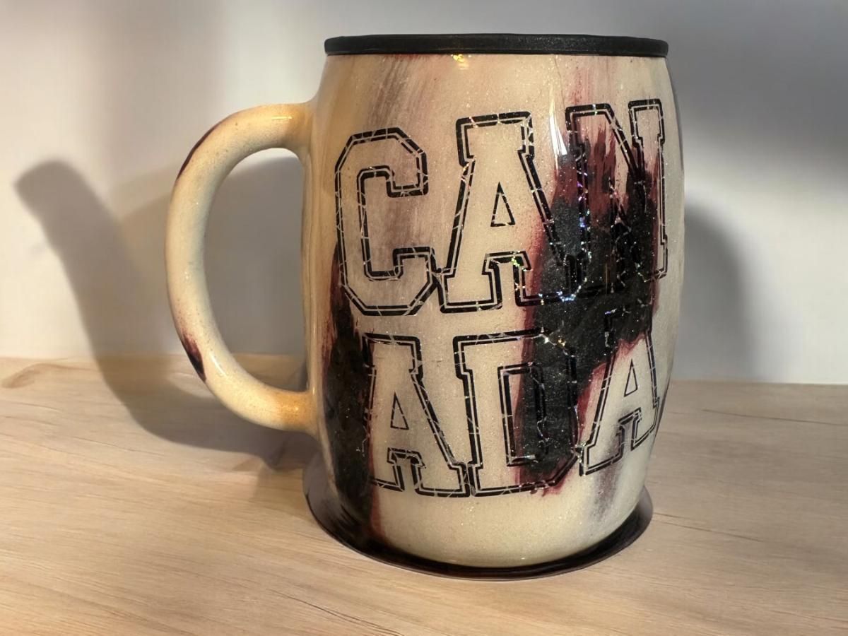 A coffee mug with the words can atlanta written on it is sitting on a wooden table.