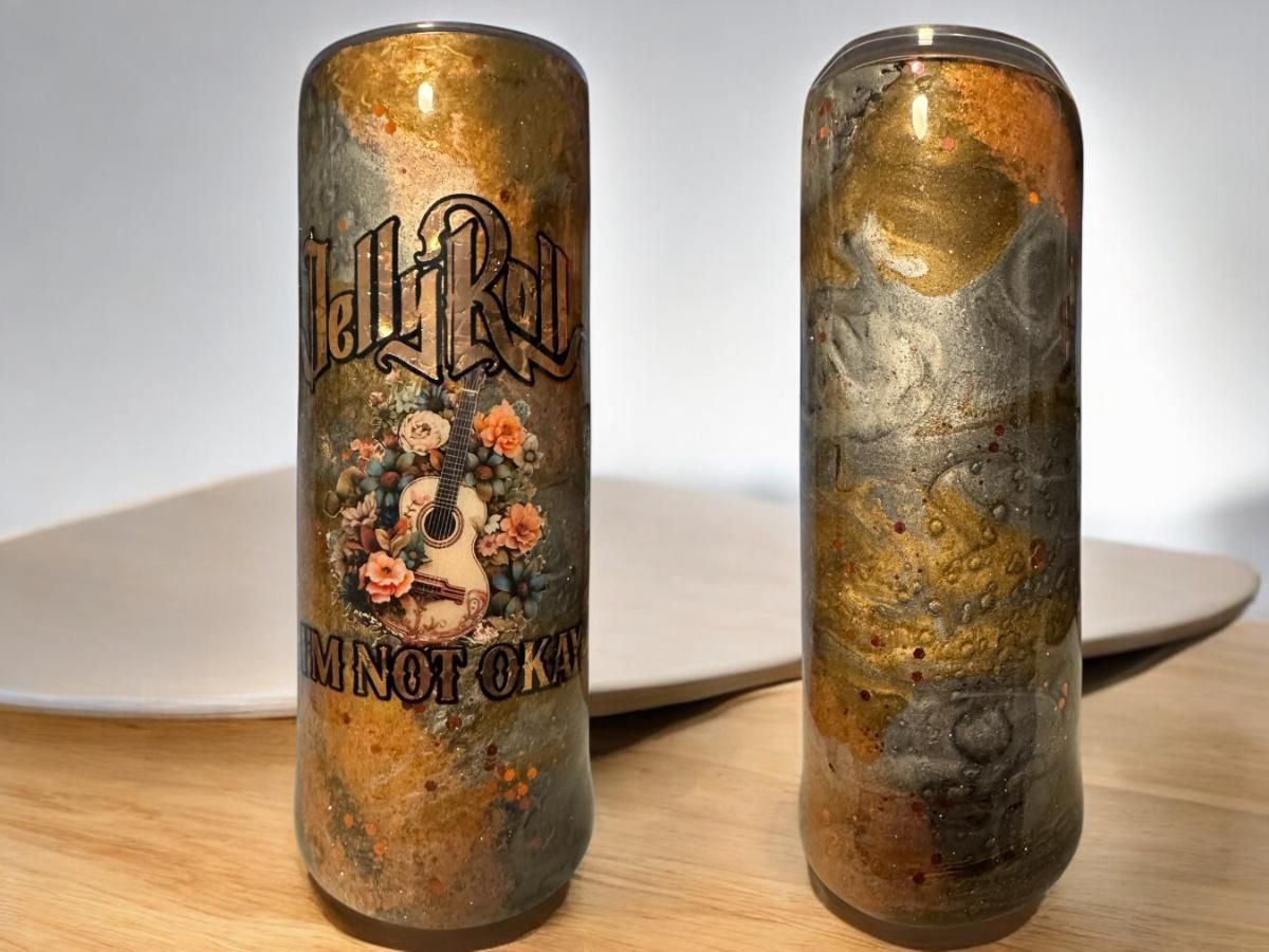Two tall, decorative tumblers. One features a guitar and floral design. Both have gold, gray, and brown marbled pattern.