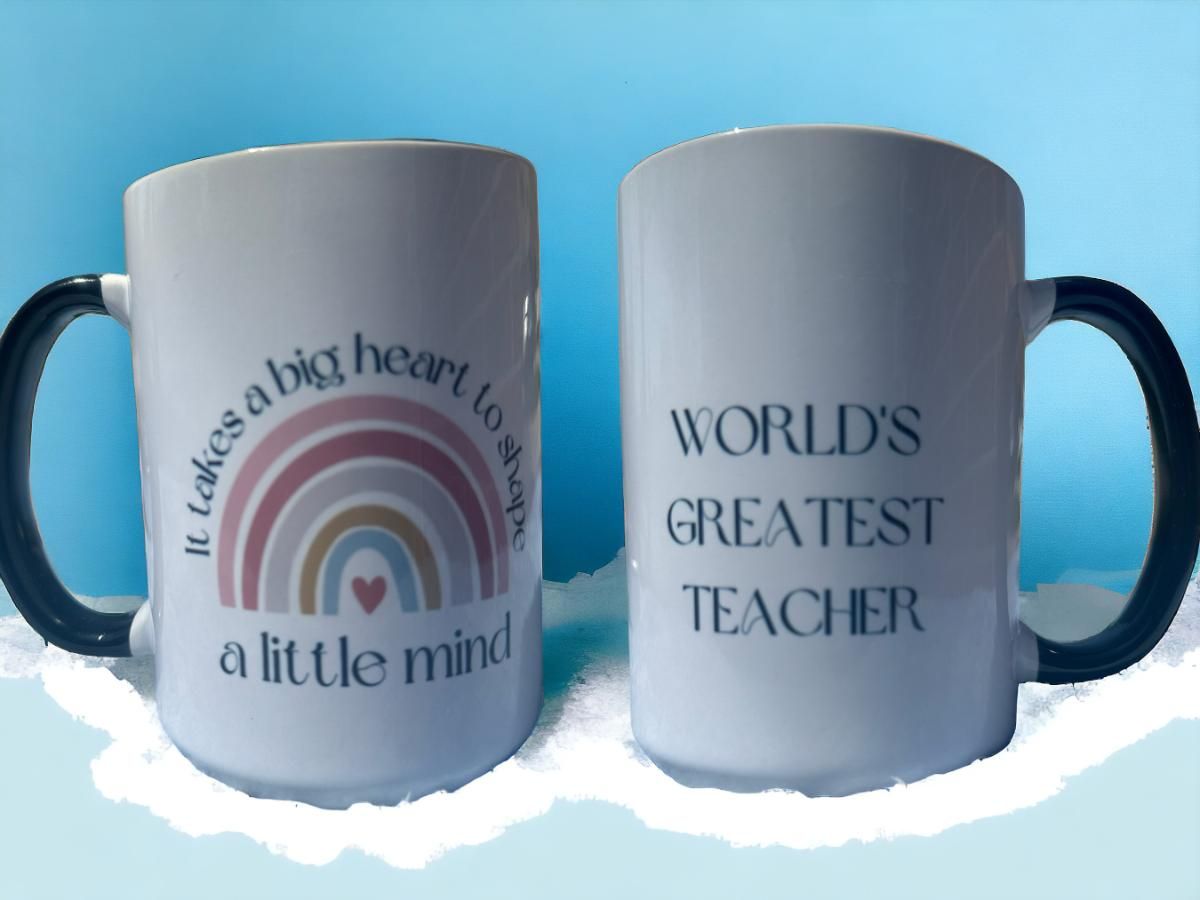 Two white mugs; one with a rainbow design and text, the other with 