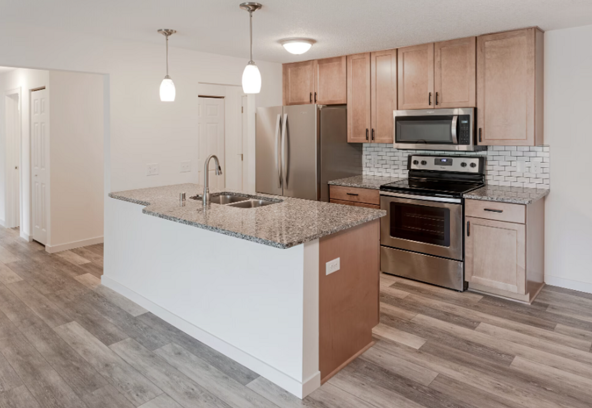 A kitchen with stainless steel appliances and granite counter tops.