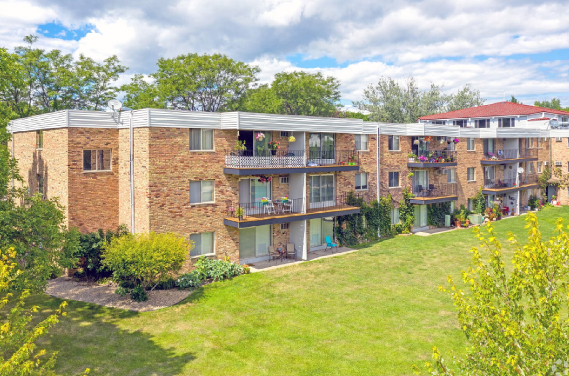 A large brick apartment building sitting on top of a grassy hill.