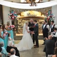 Wedding couple exchanging vows at an indoor ceremony with guests watching