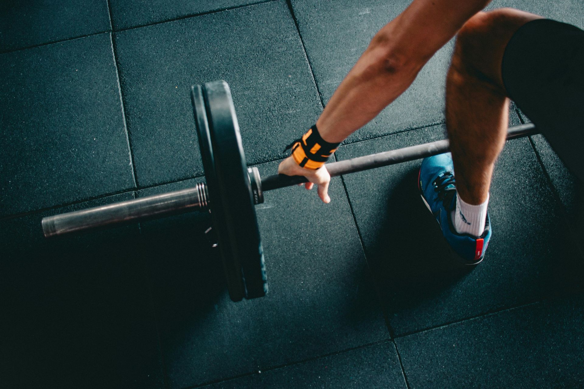 A person is lifting a barbell in a gym.