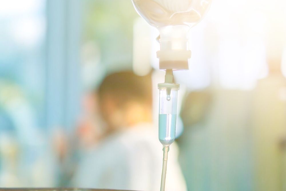 A close up of an intravenous drip in a hospital room.