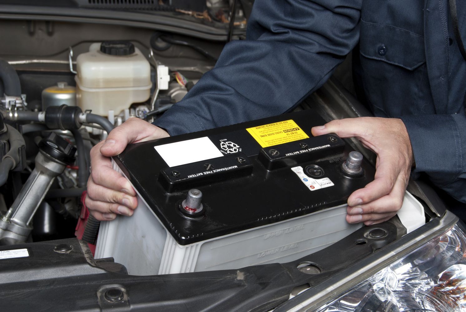 Mechanic is removing a car battery