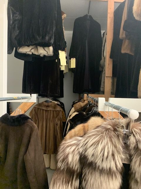 A closet filled with fur coats and jackets