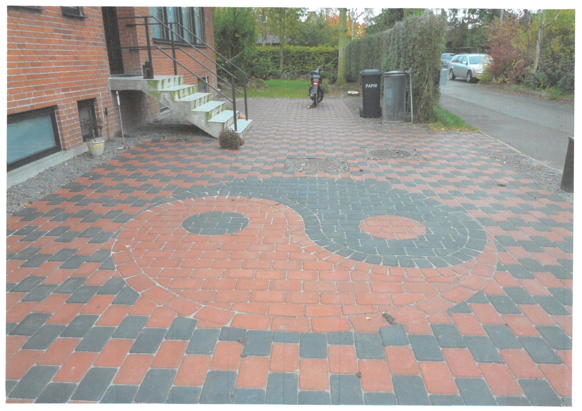 Brolagt hovedindgang med et Yin og Yang-symbol foran et hjem