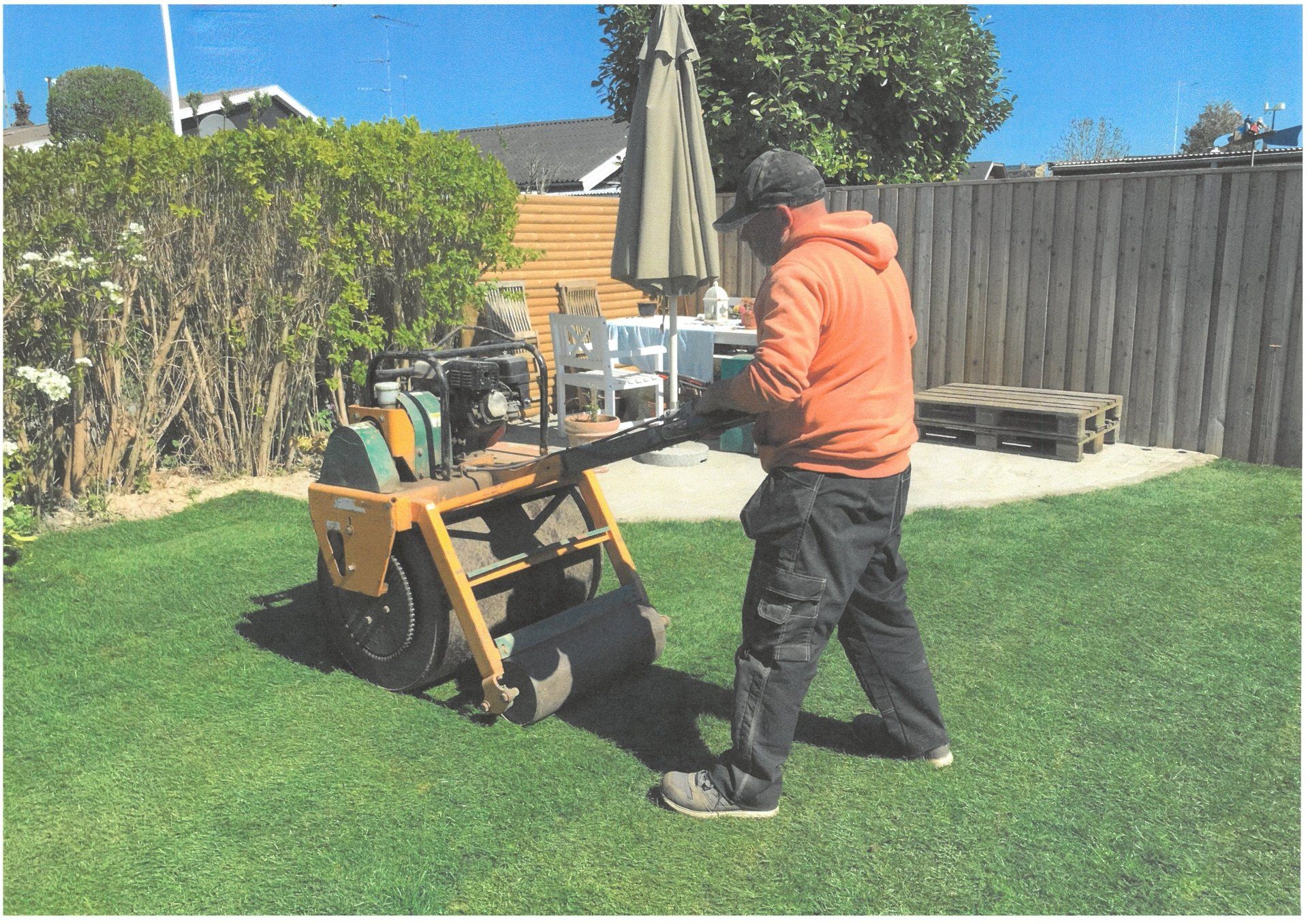 Mand flader græs med en stor maskine