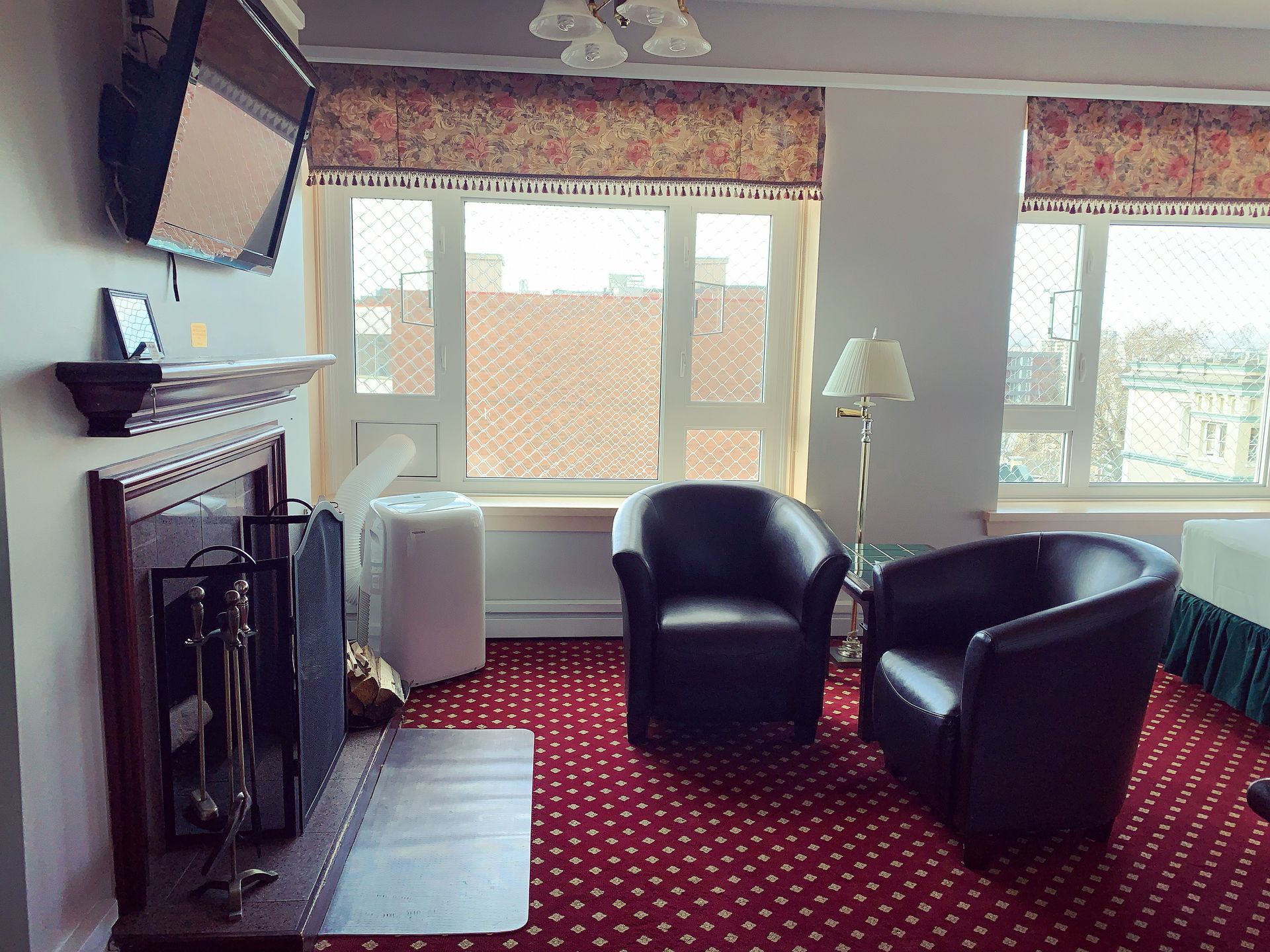 A hotel room with two chairs and a fireplace