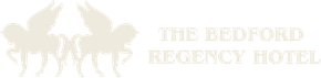 A white logo for the bedford regency hotel