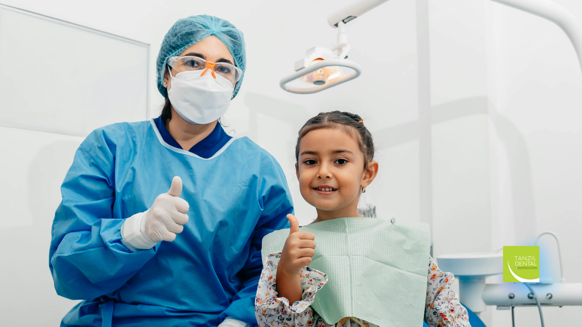 Dentist and young girl smiling, both giving thumbs up at a dental clinic.