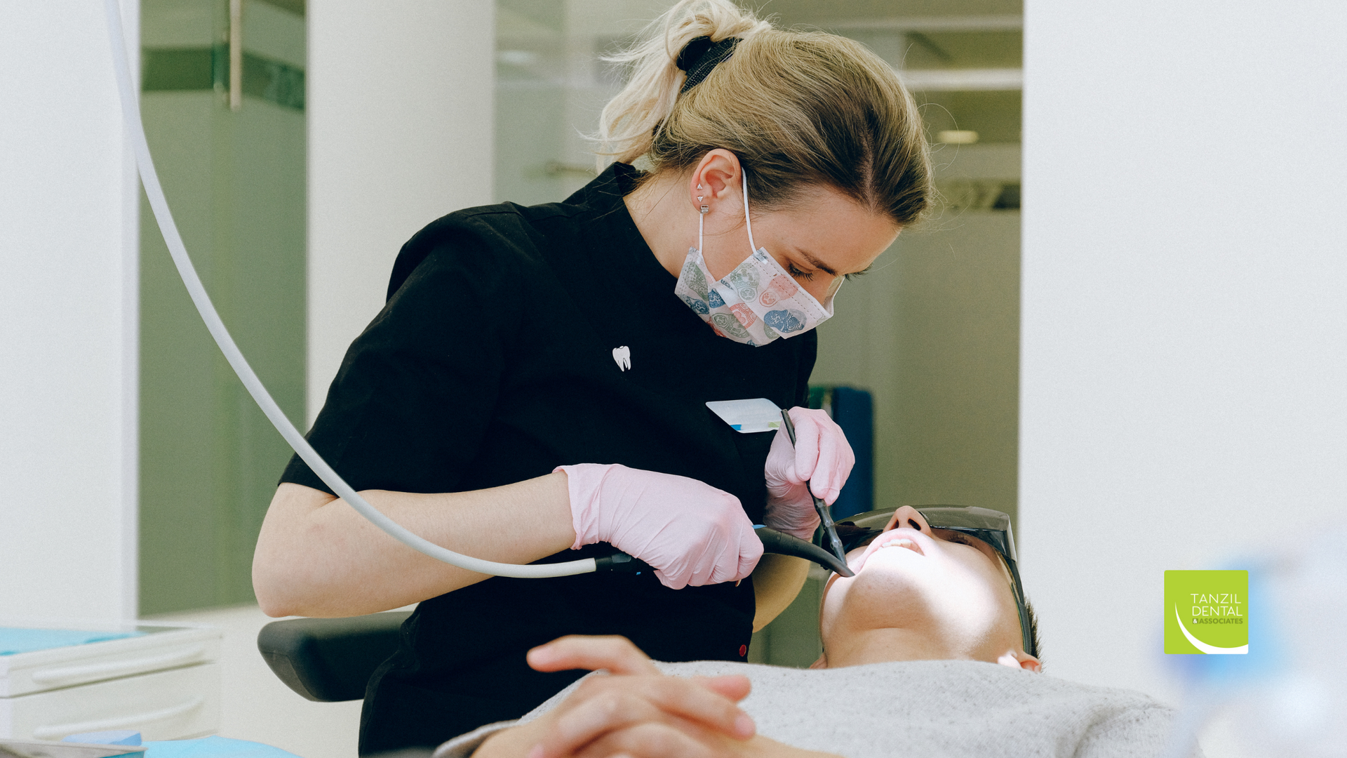 A female dentist is examining a patient 's teeth in a dental office.